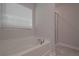 Bright bathroom featuring a soaking tub under a window and a glass-enclosed shower at 488 Charleston Pl, Villa Rica, GA 30180