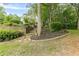 Landscaped backyard features stone steps, mature trees and lush foliage, offering privacy at 9707 Squirrel Wood Run, Douglasville, GA 30135