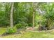 The backyard features a serene garden setting with stone steps, lush greenery, and mature trees at 9707 Squirrel Wood Run, Douglasville, GA 30135