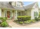 Inviting front porch with well-kept landscaping, complemented by a vibrant red door at 9707 Squirrel Wood Run, Douglasville, GA 30135