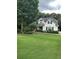 Charming home with lush green lawn, mature trees and manicured landscaping at 9707 Squirrel Wood Run, Douglasville, GA 30135