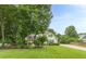 Spacious lawn surrounds a home, framed by mature trees, offering a serene, lush setting at 9707 Squirrel Wood Run, Douglasville, GA 30135