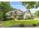 Charming home with a manicured lawn, lush landscaping, and a welcoming red front door at 9707 Squirrel Wood Run, Douglasville, GA 30135