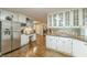 Bright kitchen featuring white cabinets, hardwood floors, stainless steel appliances, and an eat-in island at 9707 Squirrel Wood Run, Douglasville, GA 30135