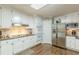 Kitchen with stainless steel appliances, white cabinets, hardwood floors, and tile backsplash at 9707 Squirrel Wood Run, Douglasville, GA 30135