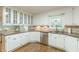 Bright kitchen featuring white cabinetry, granite countertops, stainless steel appliances and hardwood floors at 9707 Squirrel Wood Run, Douglasville, GA 30135