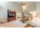 Living room with a ceiling fan, TV, staircase in the back, and hardwood floors in the entryway at 9707 Squirrel Wood Run, Douglasville, GA 30135