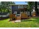 Spacious backyard with a dark two-story home, deck with outdoor kitchen, and green lawn at 1558 Line St, Decatur, GA 30032