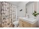 Bathroom features a vanity, framed mirror, patterned tile floor and shower with patterned curtain at 1558 Line St, Decatur, GA 30032