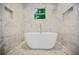 Bright bathroom featuring white marble walls and a free-standing soaking tub at 1558 Line St, Decatur, GA 30032