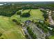 Aerial view featuring the golf course, sports fields, tennis court, and the well-appointed clubhouse with ample parking at 1604 Falcon Ct, Locust Grove, GA 30248