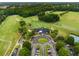 Aerial view of the golf course, clubhouse, tennis court and parking lot offering recreational opportunities and convenience at 1604 Falcon Ct, Locust Grove, GA 30248