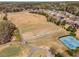 Aerial view of the golf course with the driving range and tennis courts at 1604 Falcon Ct, Locust Grove, GA 30248