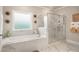 Modern bathroom featuring a glass enclosed shower, soaking tub, and a large window at 1604 Falcon Ct, Locust Grove, GA 30248