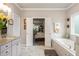 Inviting bathroom with a soaking tub, marble floors, granite counters, and access to the main bedroom at 1604 Falcon Ct, Locust Grove, GA 30248