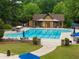 Large community pool area with lounge chairs, tables, and umbrellas, surrounded by well-maintained landscaping and a clubhouse at 1604 Falcon Ct, Locust Grove, GA 30248
