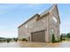Side view of an elegant brick home featuring an attached garage at 1604 Falcon Ct, Locust Grove, GA 30248