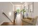 Bright hallway with wood floors, trim, chandelier, and a chair with plants for decor at 1604 Falcon Ct, Locust Grove, GA 30248