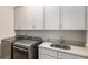 Well-equipped laundry room with gray cabinets, granite counters, and stainless steel washer and dryer at 1604 Falcon Ct, Locust Grove, GA 30248