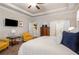 Elegant main bedroom with tray ceilings, ceiling fan, and sitting area with natural light from large windows at 1604 Falcon Ct, Locust Grove, GA 30248