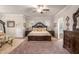 Spacious main bedroom with decorative ceiling, ceiling fan, sitting area, and adjoining bathroom at 1604 Falcon Ct, Locust Grove, GA 30248