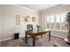 Well-lit home office featuring a large glass desk, shuttered windows, and neutral tones at 1604 Falcon Ct, Locust Grove, GA 30248