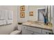 Stylish powder room with granite countertop, white cabinets, and modern fixtures at 1604 Falcon Ct, Locust Grove, GA 30248