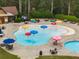 Community splash pad with colorful mushroom fountains, lounge chairs, and umbrella-covered tables for resident enjoyment at 1604 Falcon Ct, Locust Grove, GA 30248