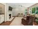 Bright living room featuring a brick fireplace, built-in bar, comfortable seating, and a large window at 3042 Argonne Dr, Atlanta, GA 30305