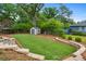 Well-manicured backyard featuring an artificial turf area, storage shed, and mature trees for added privacy at 834 Timberland Se St, Smyrna, GA 30080