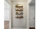 Hallway with wood floors, multiple shelves with pictures, leading to a room with a door at 834 Timberland Se St, Smyrna, GA 30080