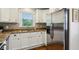 Updated kitchen featuring stainless steel refrigerator, white cabinets, granite countertops, and window view at 834 Timberland Se St, Smyrna, GA 30080