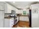 Bright kitchen featuring white cabinetry, stainless steel appliances, granite countertops, and hardwood flooring at 834 Timberland Se St, Smyrna, GA 30080