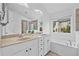 Bathroom featuring a double vanity, soaking tub, and large window at 3729 Inglewood Ne Way, Atlanta, GA 30319