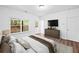 Main bedroom with hardwood floors, TV, and a sliding glass door to the backyard at 3729 Inglewood Ne Way, Atlanta, GA 30319