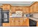 Close-up of kitchen showcasing wood cabinets, tiled backsplash, and modern black appliances at 422 Inwood Trail Trl, Lawrenceville, GA 30043