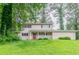 Charming two-story home with a covered front porch and mature trees at 4715 Wildginger Run, Lithonia, GA 30038