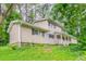 Side view of home showing neutral siding, covered front porch and lush greenery at 4715 Wildginger Run, Lithonia, GA 30038