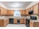Traditional kitchen featuring wood cabinets, tile countertops, and black appliances at 4715 Wildginger Run, Lithonia, GA 30038