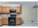 The kitchen has wood cabinets, tile countertops, and black appliances at 4715 Wildginger Run, Lithonia, GA 30038