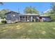 Spacious backyard with lush green grass, a patio and screened porch at 6085 Dunbritan Ln, Atlanta, GA 30349