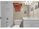 Bright bathroom featuring a shower-tub combo, white cabinets, and a bronze towel rack with plush orange towels at 6260 Sturbridge Ln, Cumming, GA 30040