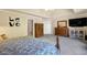 View of a spacious carpeted primary bedroom with a mounted television and and dressers at 6260 Sturbridge Ln, Cumming, GA 30040