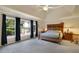 Spacious bedroom with tray ceilings, large windows, dark drapes, and a ceiling fan with a light fixture at 6260 Sturbridge Ln, Cumming, GA 30040