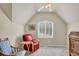 Cozy bedroom featuring a large window with shutters, and a reading chair with a small side table at 6260 Sturbridge Ln, Cumming, GA 30040