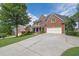 Traditional brick home with a long driveway, attached garage, and well-maintained landscaping at 6260 Sturbridge Ln, Cumming, GA 30040