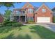 Beautiful two-story brick home featuring a covered front porch and manicured landscaping at 6260 Sturbridge Ln, Cumming, GA 30040