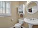Bright powder room boasts a pedestal sink, toilet, and a decorative mirror for a touch of elegance at 6260 Sturbridge Ln, Cumming, GA 30040