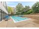 Outdoor pool with blue lounge chairs surrounded by green foliage and stone walls at 120 Ralph Mcgill Ne Blvd # 1502, Atlanta, GA 30308