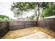 A fenced backyard with a concrete patio and mature trees providing shade at 1200 Ashborough Se Ter # A, Marietta, GA 30067